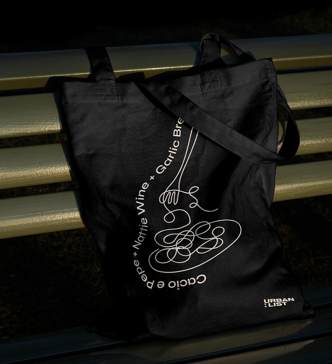 a black tote bag with a line art drawing of pasta on it