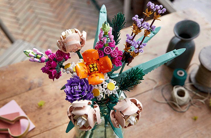 A flower bouquet made from lego featuring a range of blooms in different colours and leaves. 