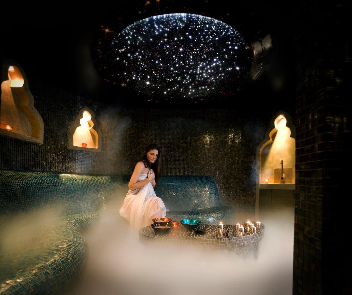 a woman in a tiled steam room