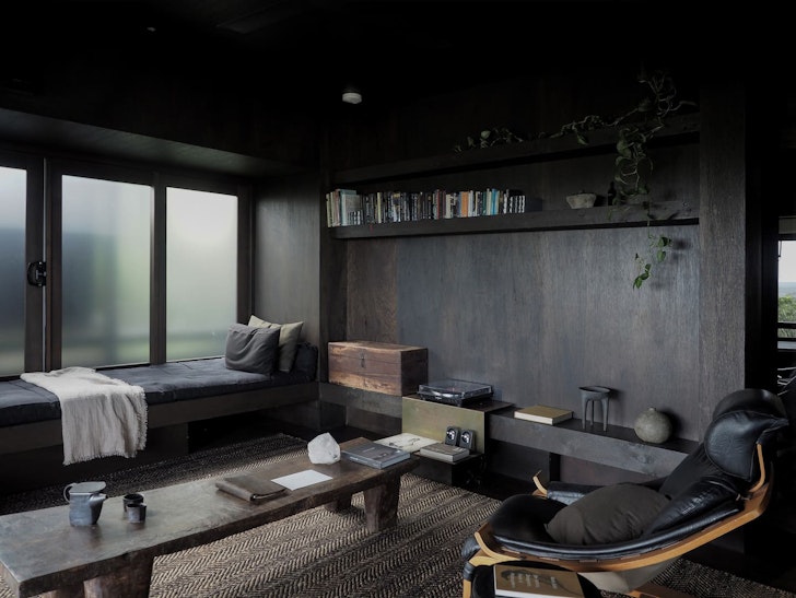 A moodily lit living room at Shack Palace Airbnb In Noosa