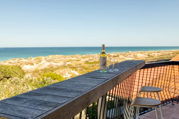 Bottle of wine rests on a bar overlooking Scarborough Beach