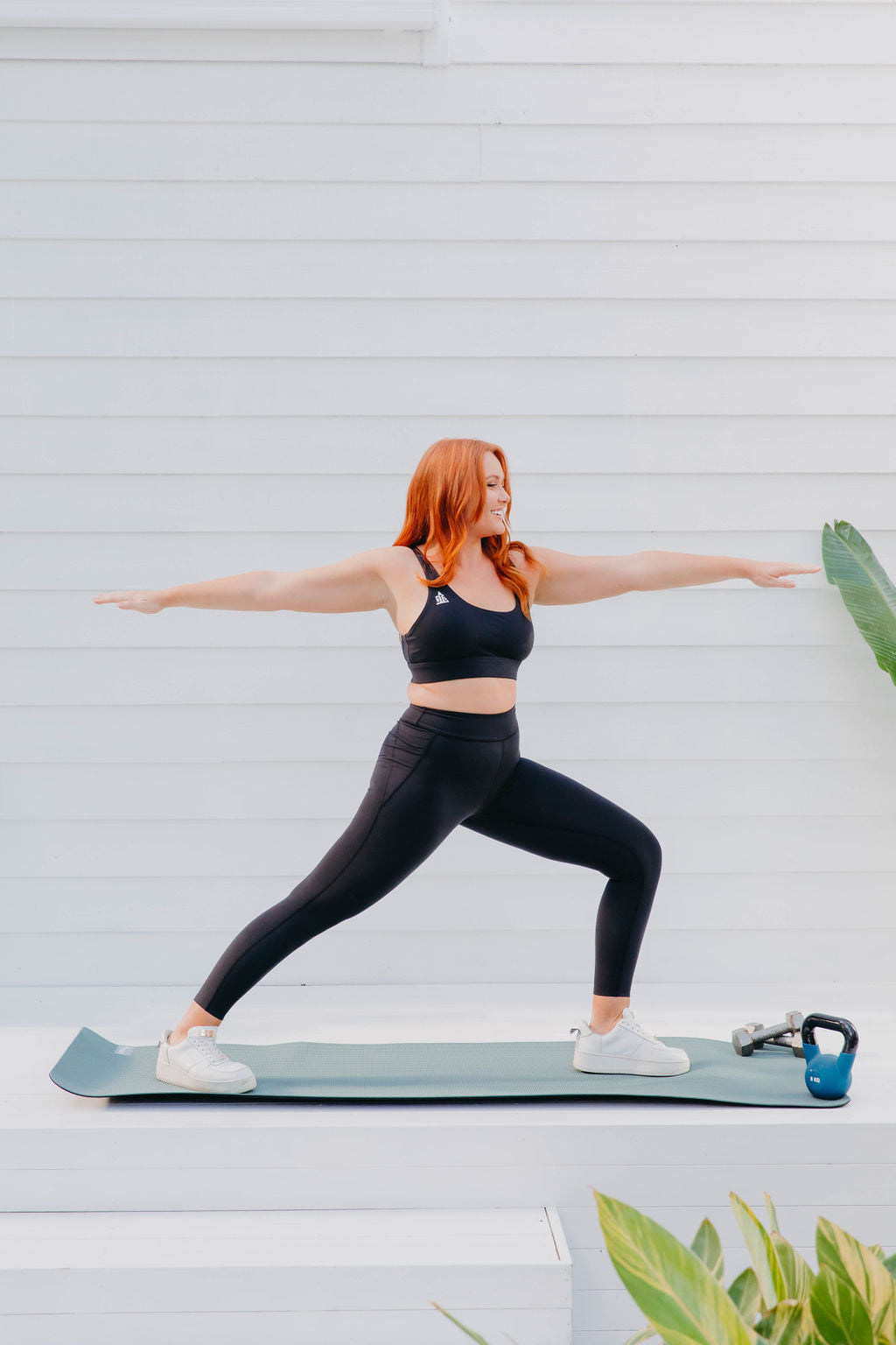 a woman in black activewear doing pilates