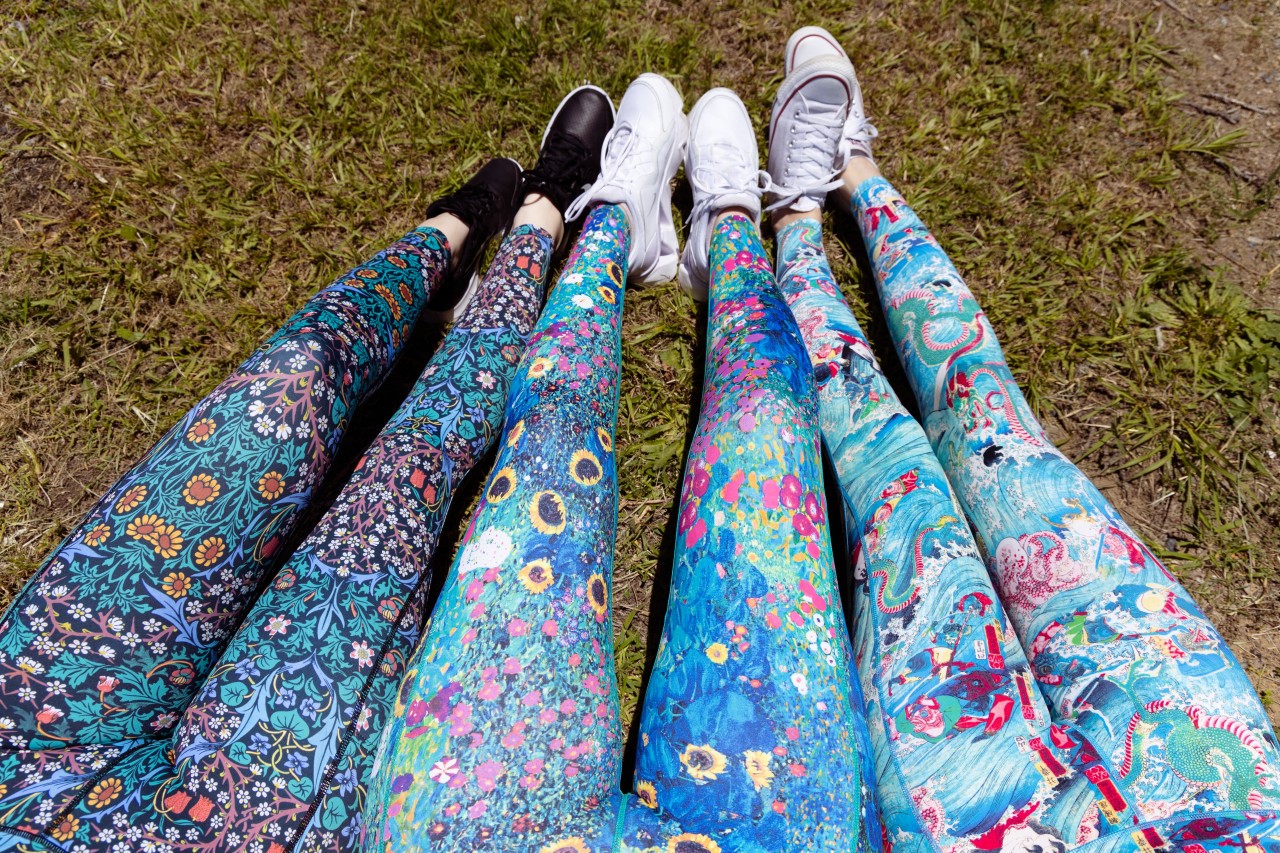 three sets of legs on grass wearing colourful tights
