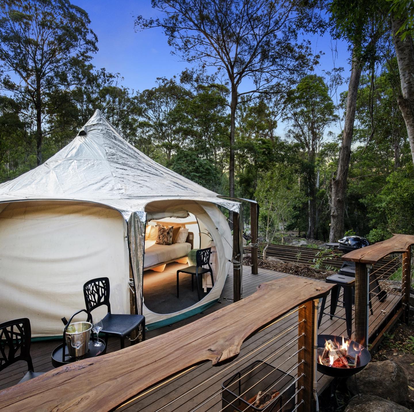 a lotus-shaped tent on a deck in the forest
