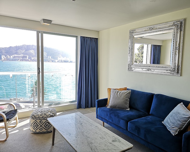 The blue couch ovelooking the water at 180-Degree View Home one of the best Wellington Airbnbs