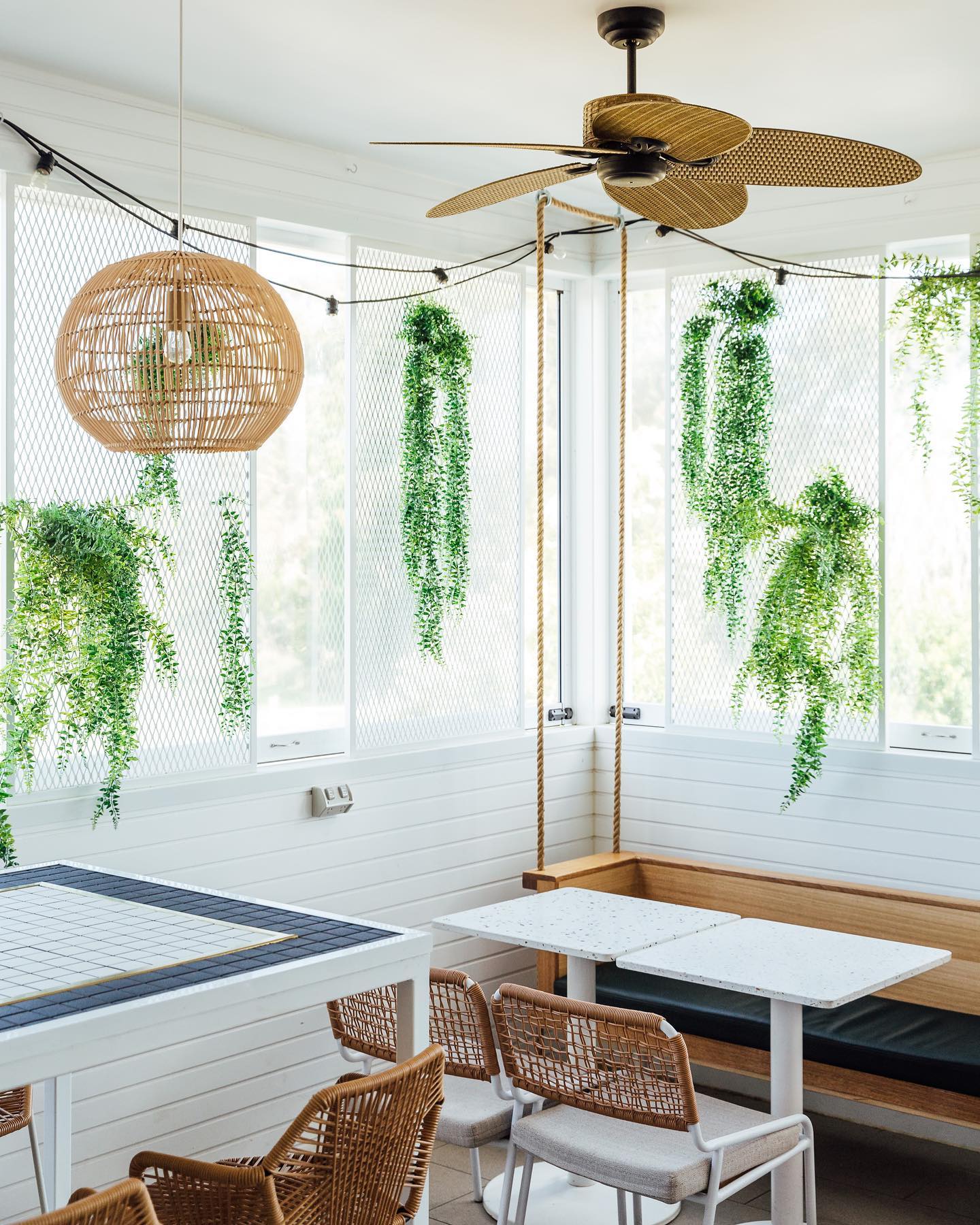 a corner of a cafe with hanging greenery