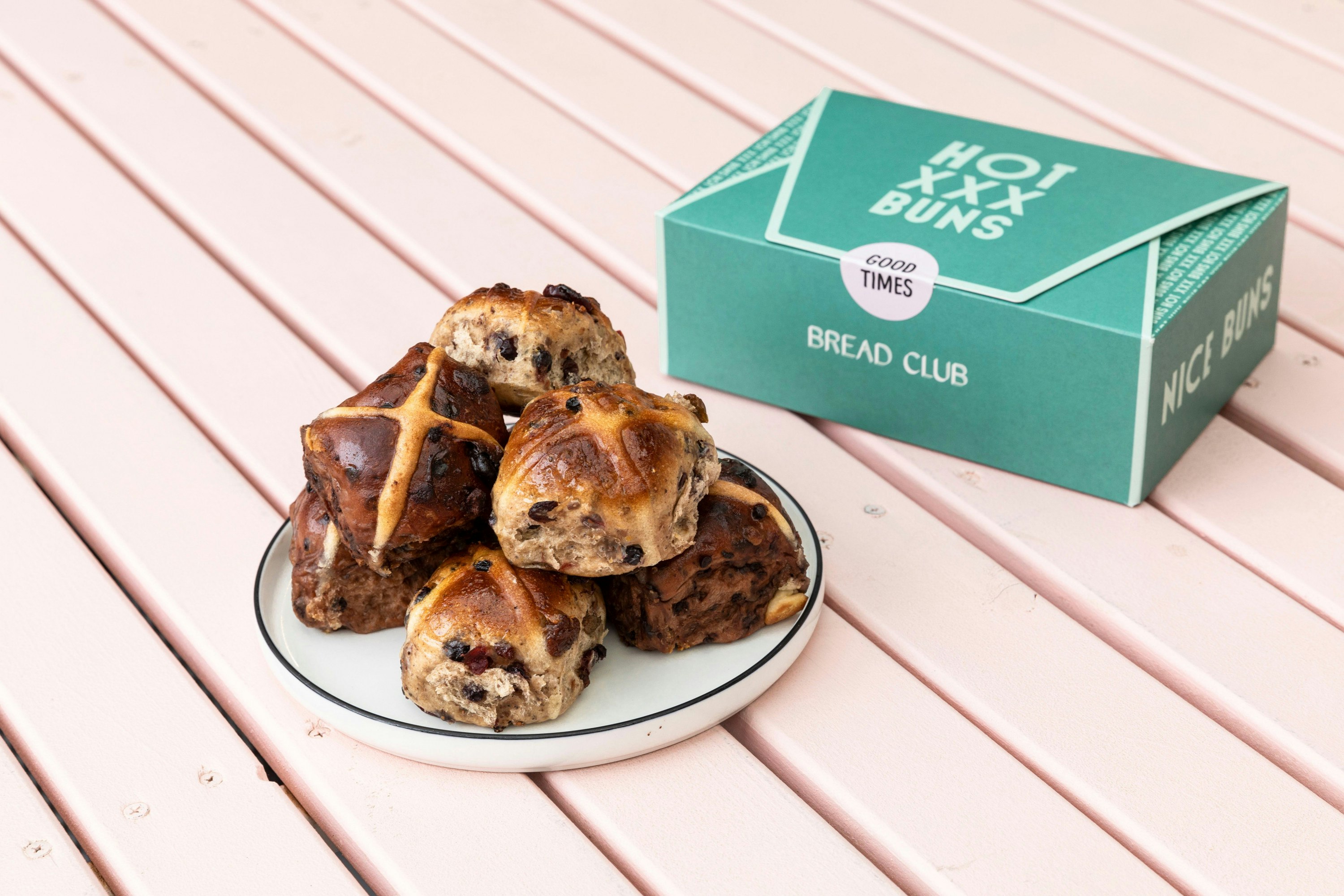 a stack of hot cross buns next to a turqoise box