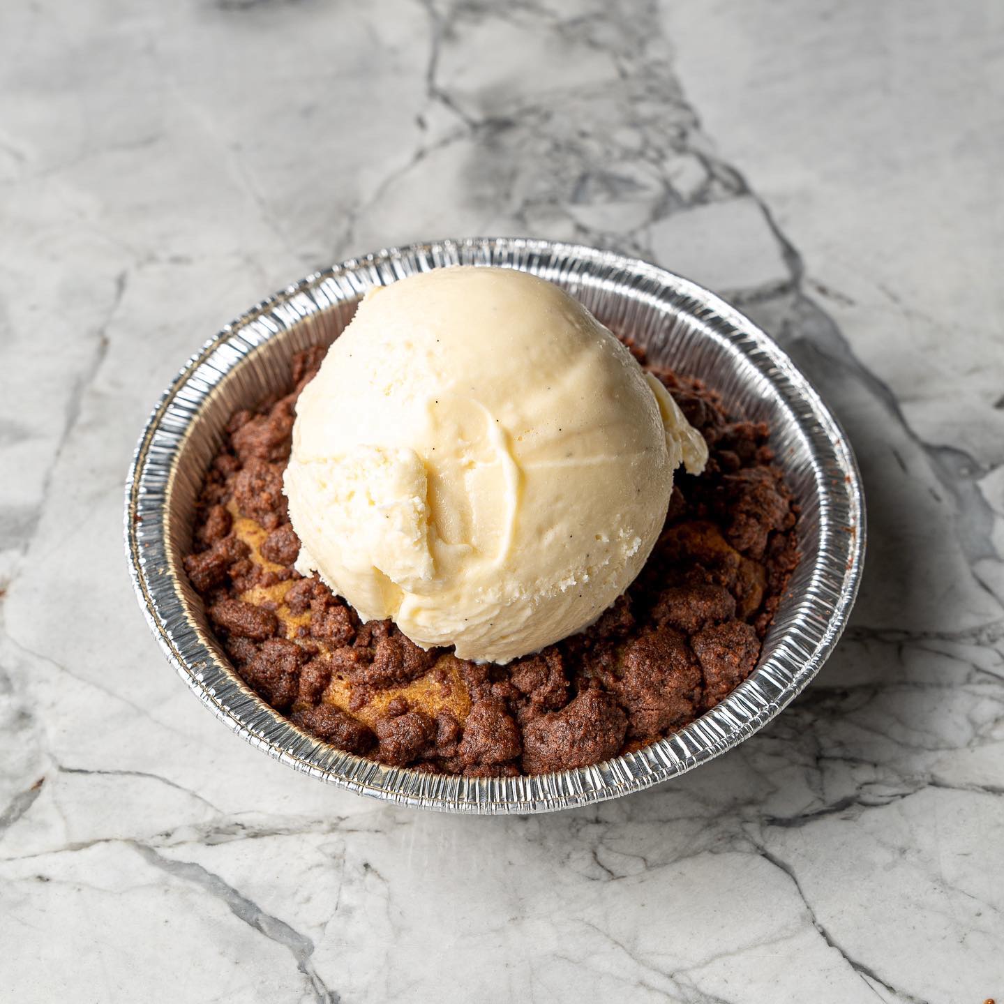 a single serve cookie pie with a scoop of gelato on top