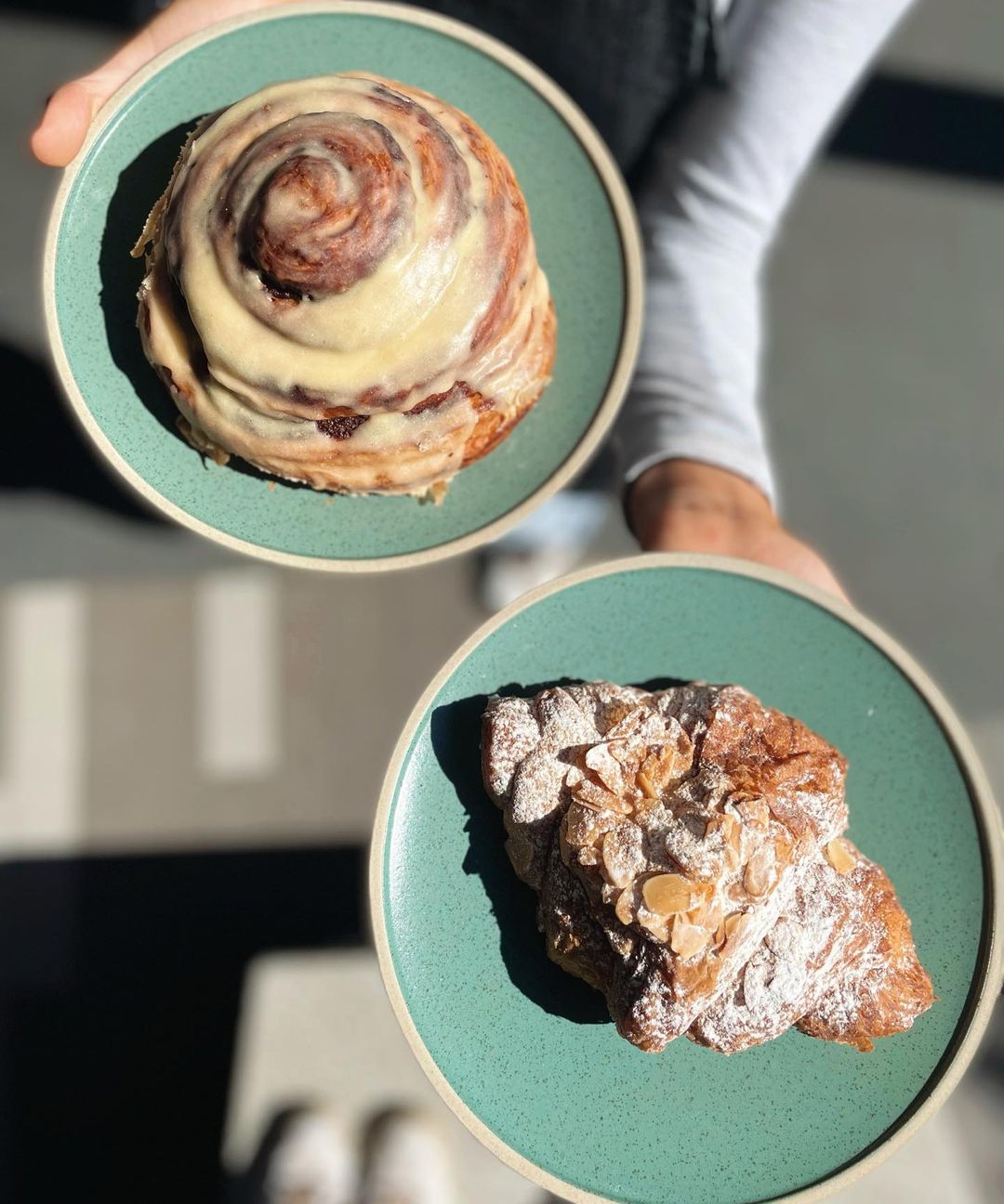 an almond croissant and an escargot on plates