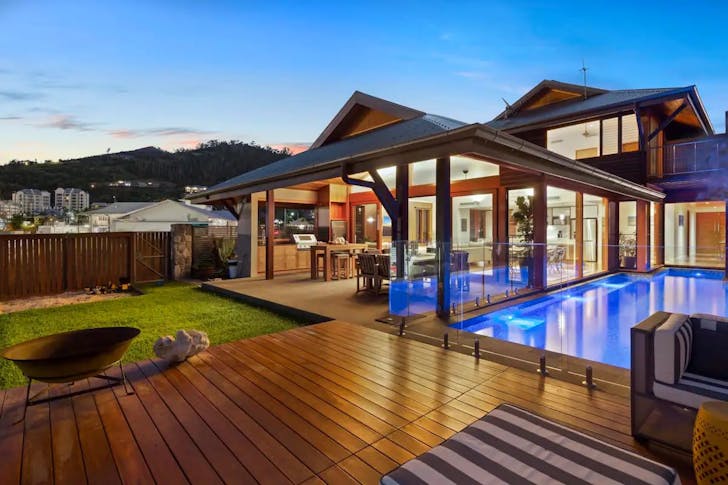 house with sweeping deck and entertainment area