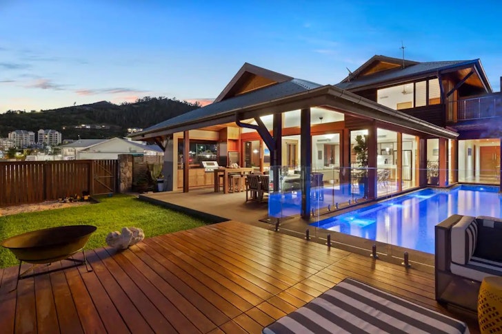 A view over the deck towards the pool and house at 23 The Cove one of the best Airlie Beach Airbnbs