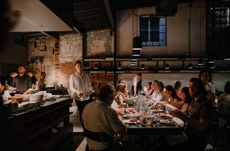 A moody dining room filled with diners at Agnes Restaurant Brisbane