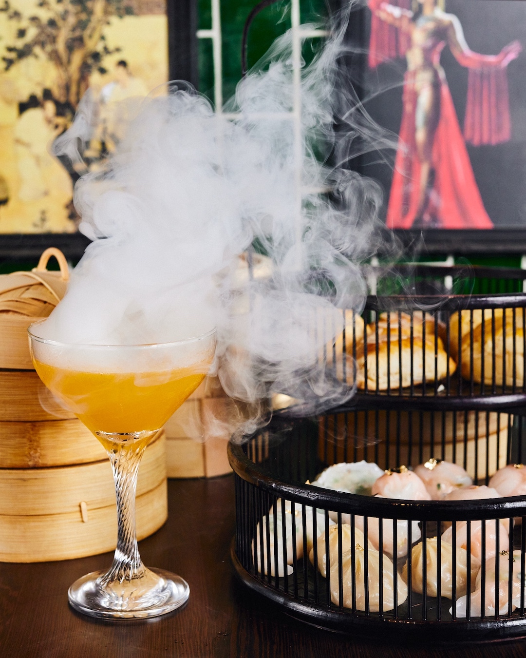 A platter of dumplings with a cocktail.