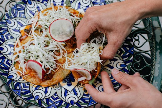 Someone scoops up a birria taco.