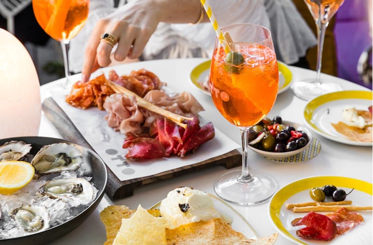 A table of Italian dishes with spritzes