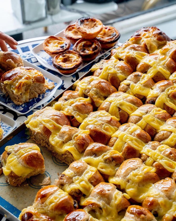 a stack of hot cross buns with a portuguese tart-style cross at sydney bakery sweet belem