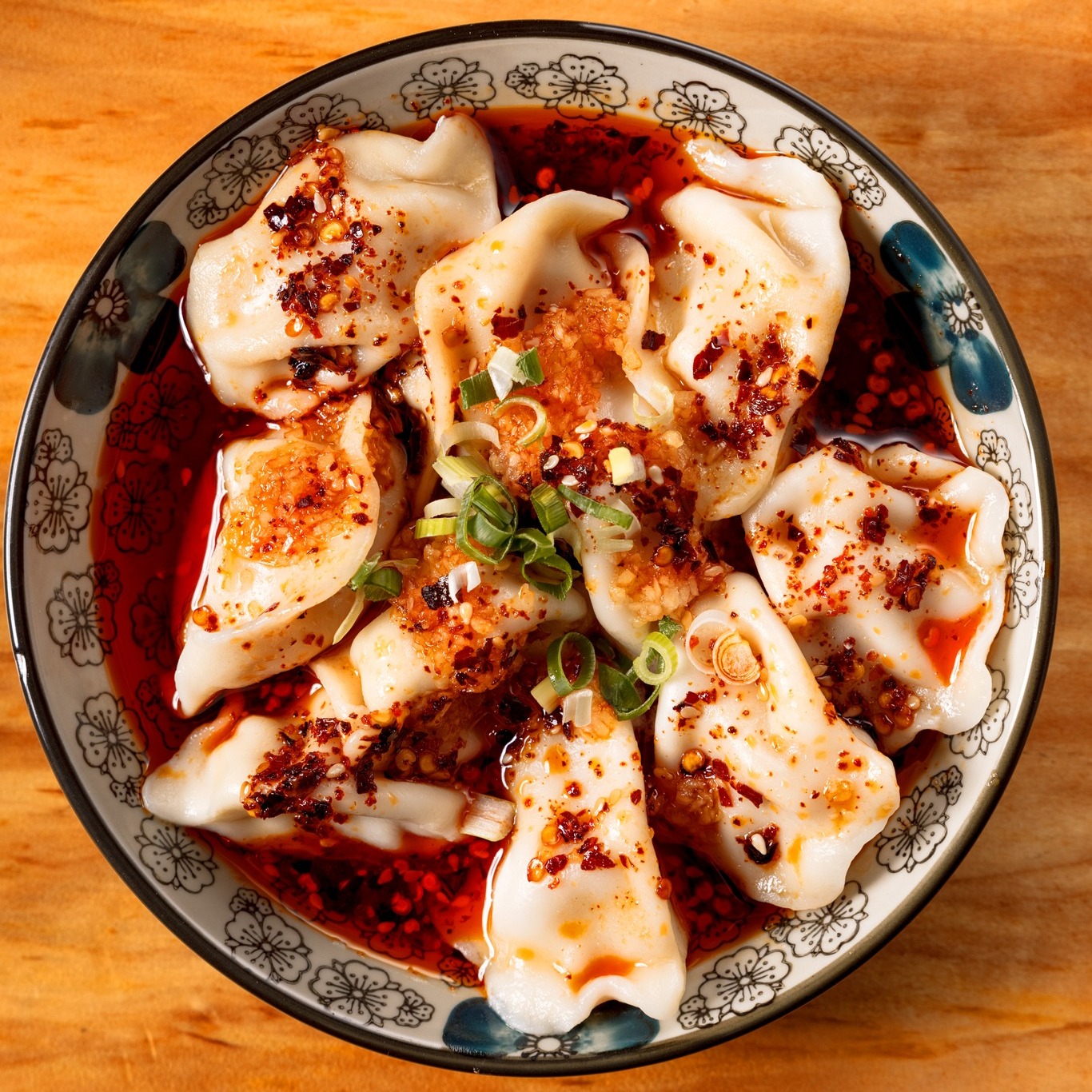 a bowl of dumplings in red sauce