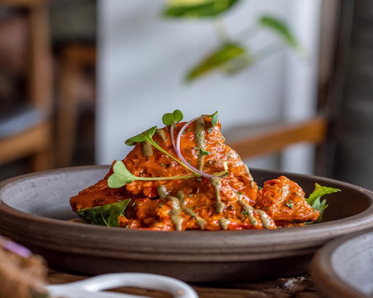 A clay pot of bright orange peri peri chicken tikka from 3Nutmegs.