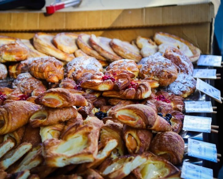 Tasty pastries lined and stacked up for sale.
