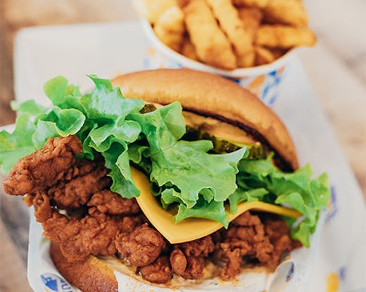 a close-up of a chicken sandwich and chips