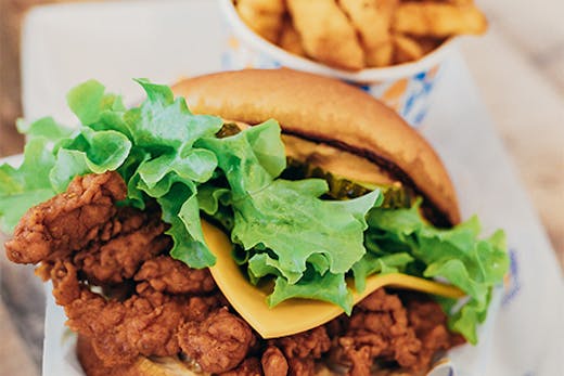 a close-up of a chicken sandwich and chips