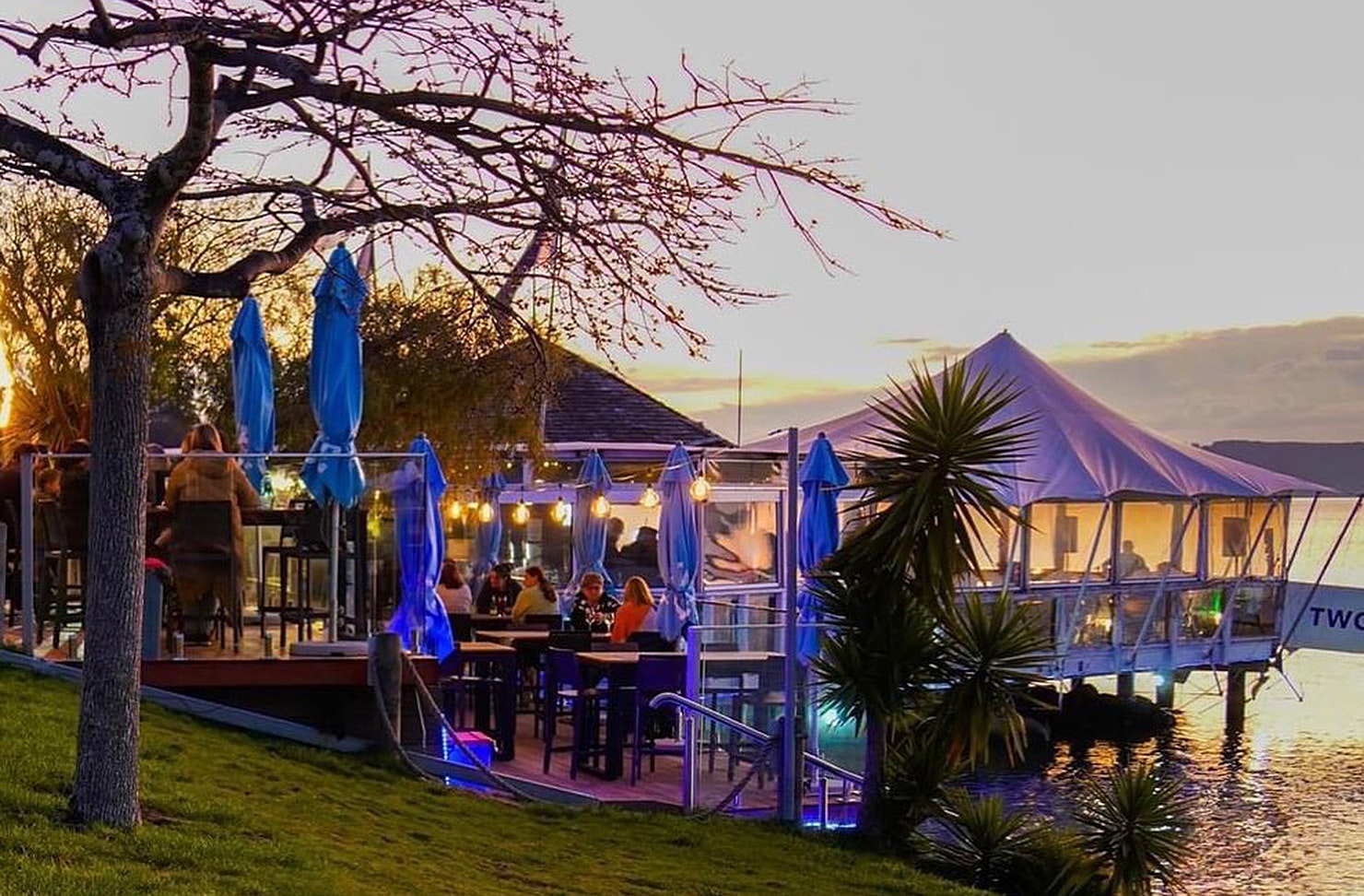 The exterior of 2 mile Taupo is lit up while people dine. One of the best restaurants in Taupo.