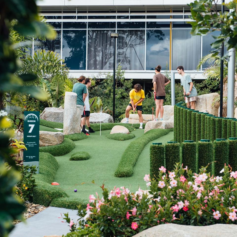 a group of guys playing putt putt