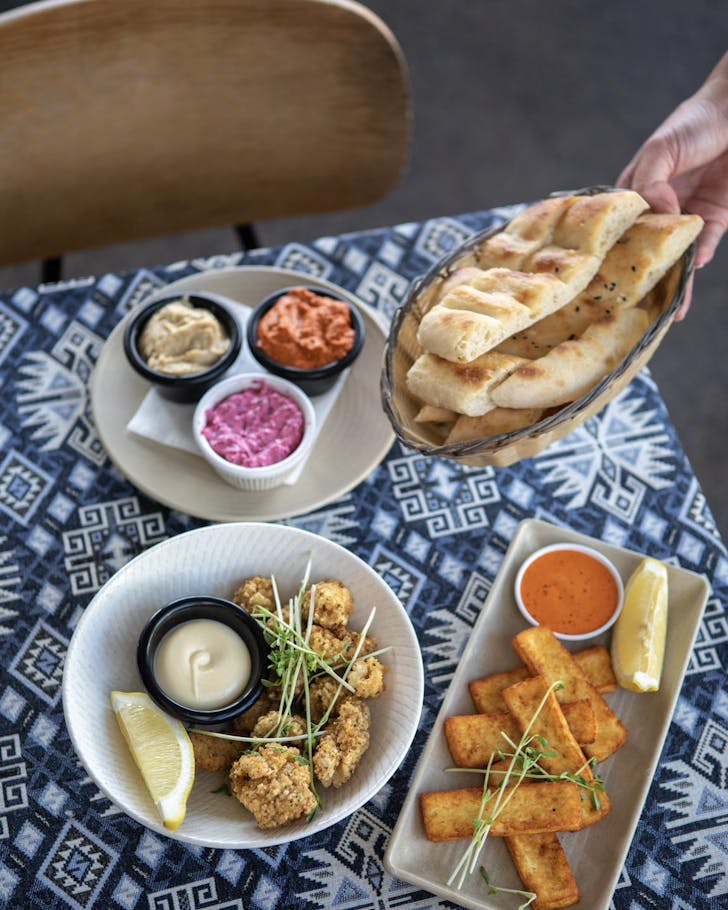 a patterned table with plates of food on it