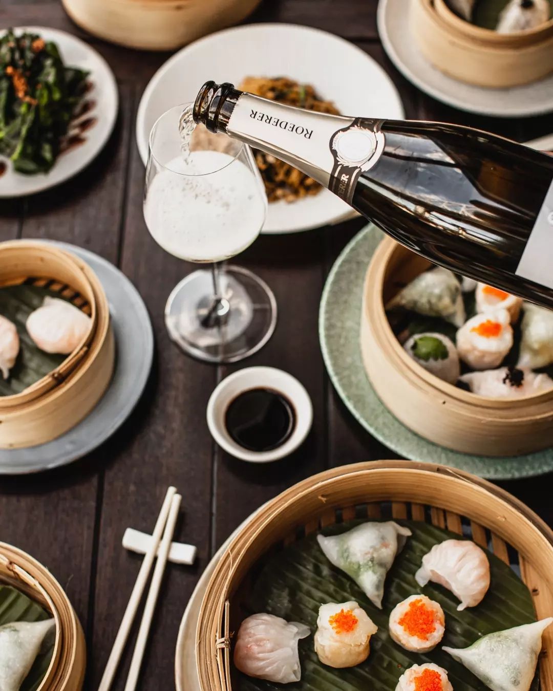 a table of dumplings with champagne being poured into a glass at Stanley, a yum cha restaurant in Brisbane