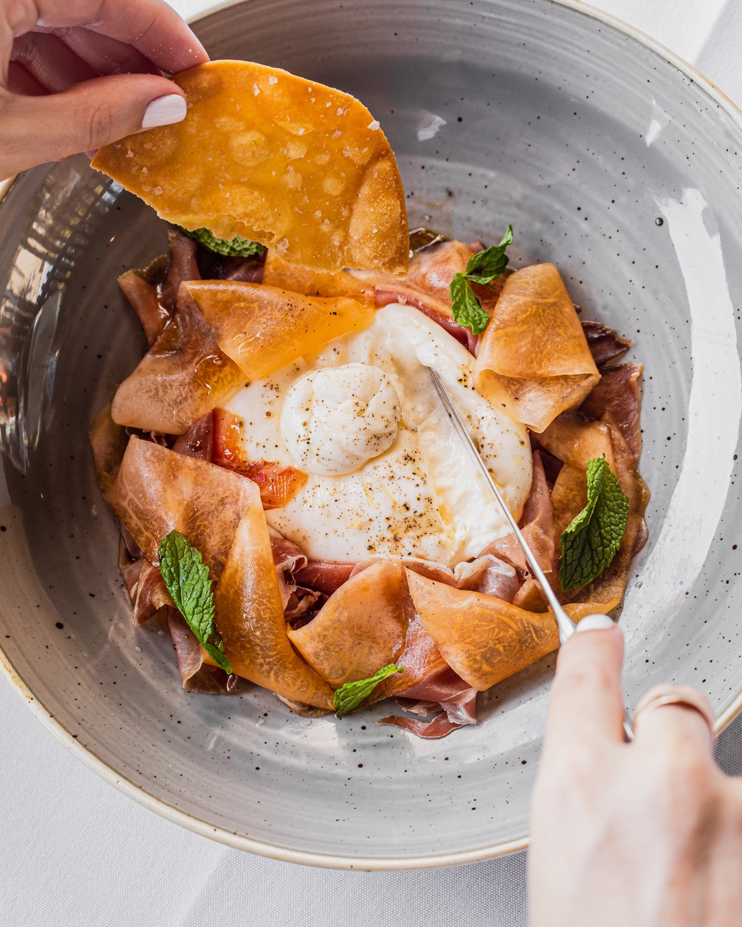 a plate of burrata and crisp bread at otto, one of brisbane's best restaurants