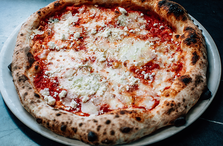 A table with a margherita pizza, one of the best pizzas in Melbourne. 
