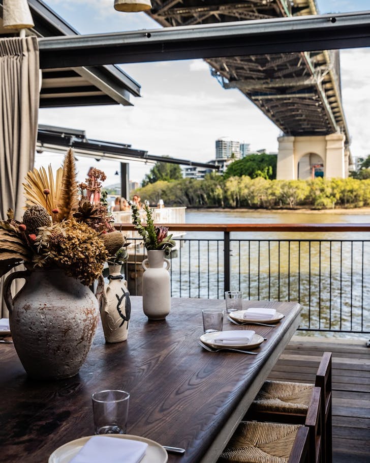 a view of the story bridge from a table at greca
