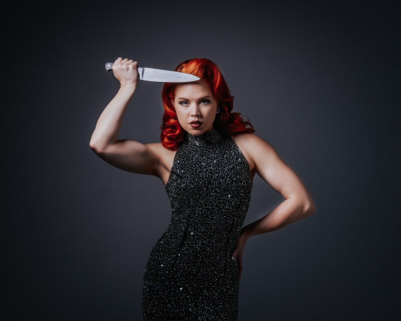 A sequin-clad burlesque dancer strikes a pose with a chef’s knife in hand