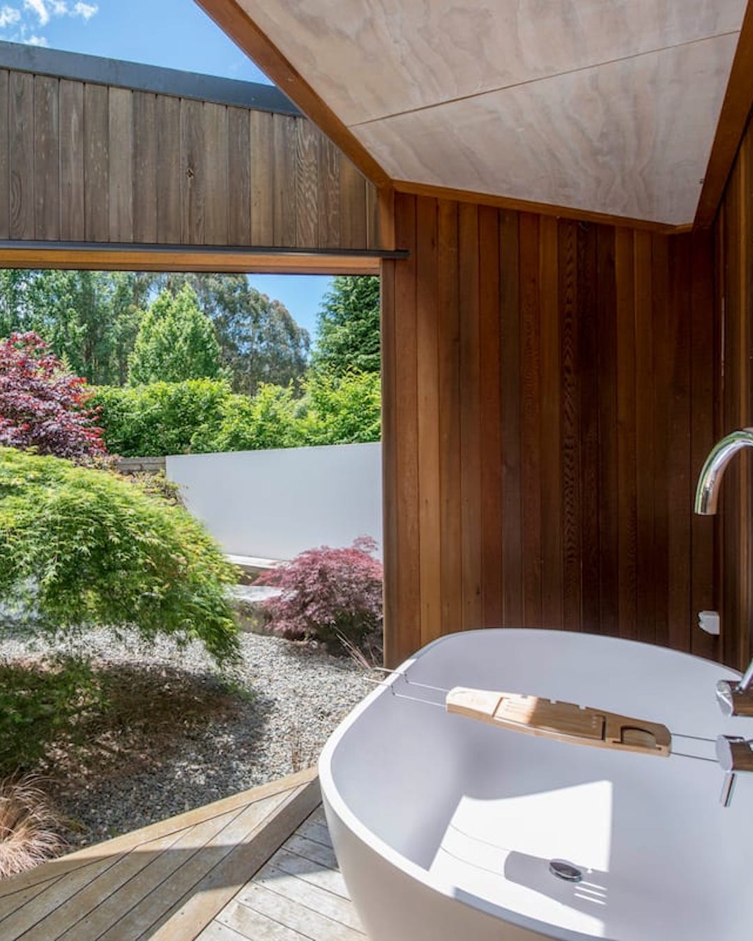 A large bathtub looking out to a Japanese-style garden