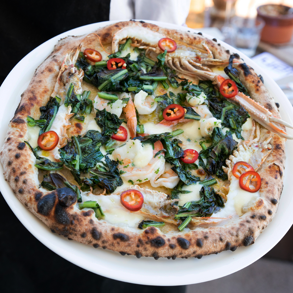 A best pizza Melbourne option with prawns, chilli and greens. 