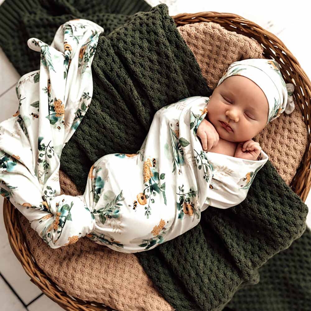 a newborn baby wrapped in a floral jersey wrap, a baby shower gift idea