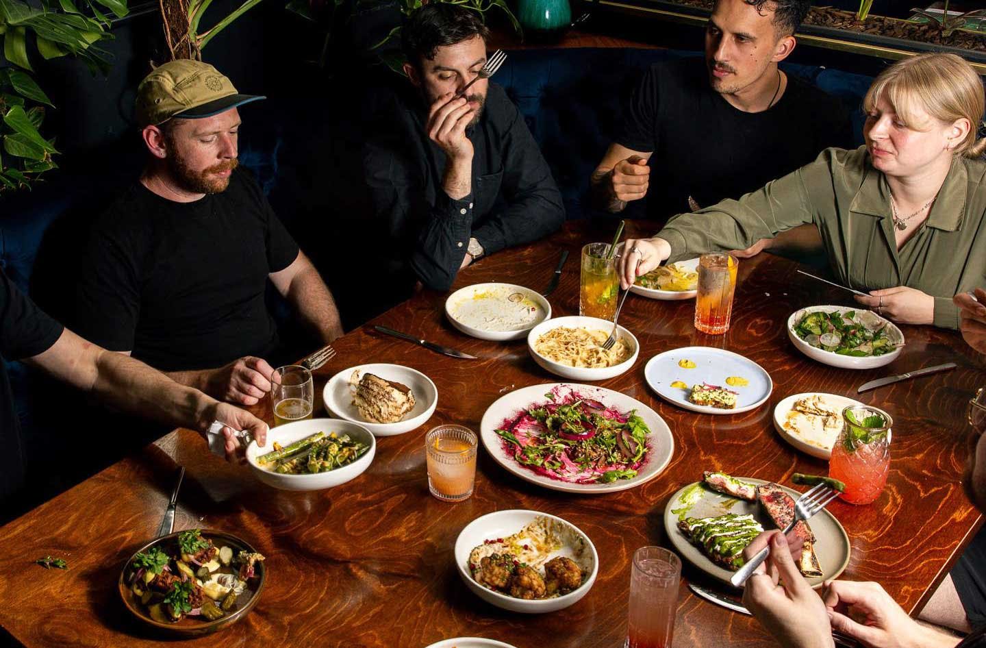 Friends sit around a table for dinner at 5th St Christchurch