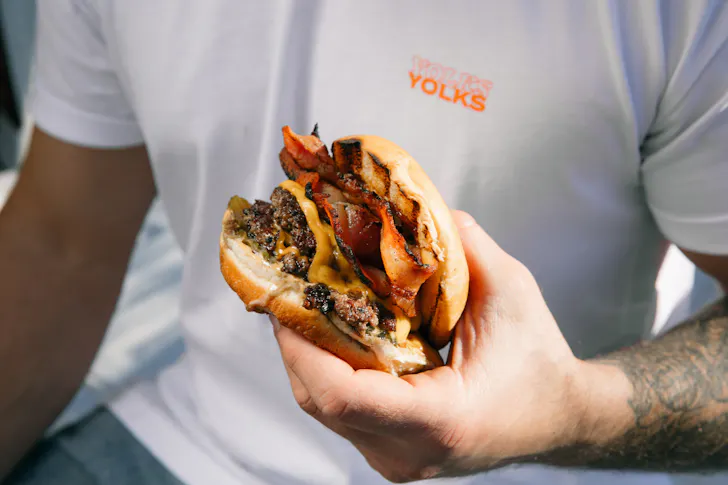 someone holding a burger