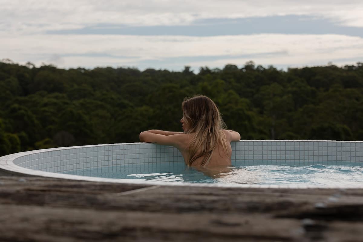 a woman in a pool overlooking the countryside