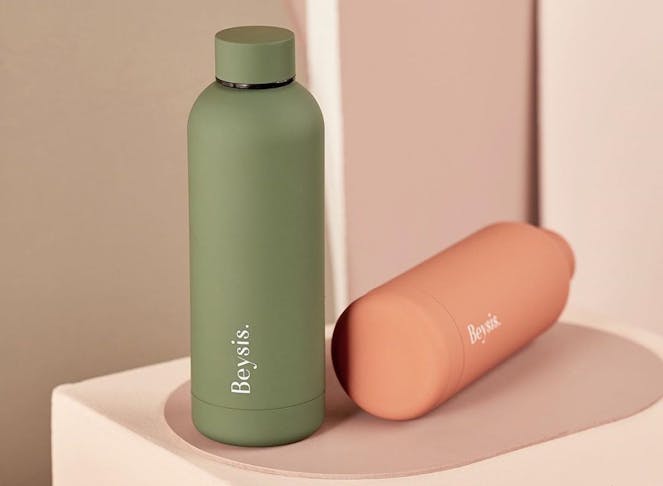A sleek green and peach water bottle lie side by side.