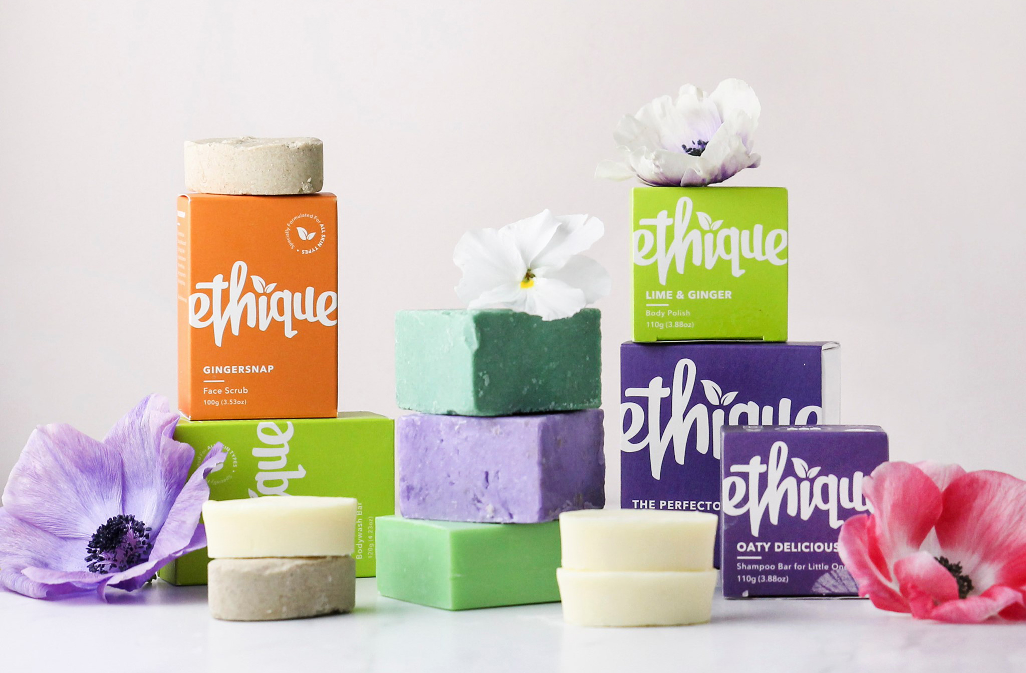 A collection of shampoo soap bars and brightly coloured boxes from Ethique