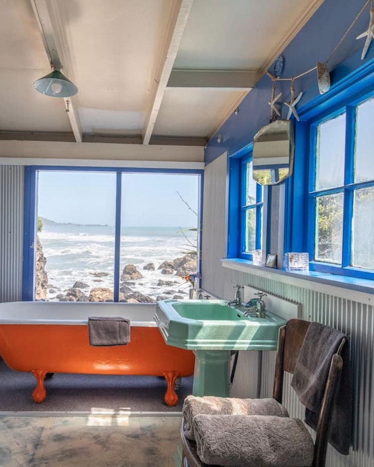 The retro bathroom with waves outside at Woodpecker Bay Bach one of the best NZ Airbnbs