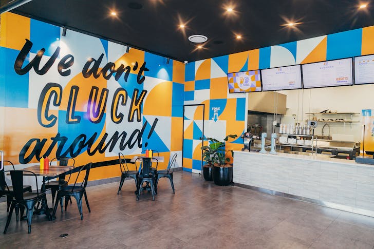 the interior of a fried chicken shop with yellow and blue accents