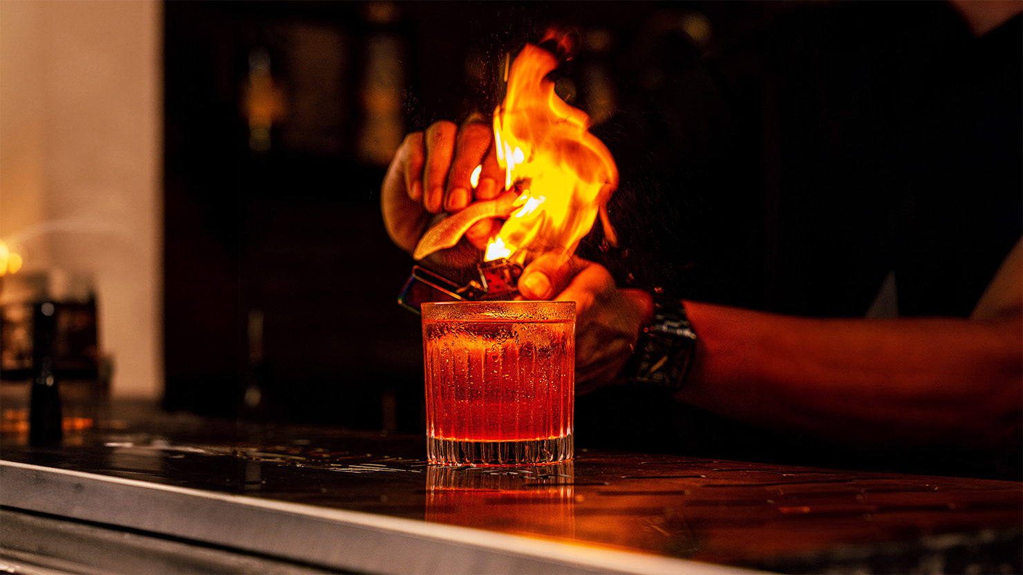 Hand lighting cocktail on fire