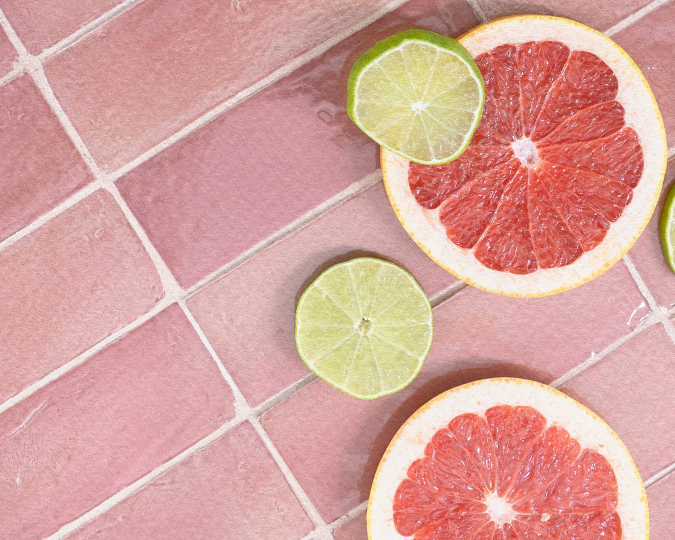A pretty pink tiled bench topped with sliced grapefruit and limes. 