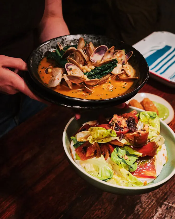 Two plates of food in dark lighting