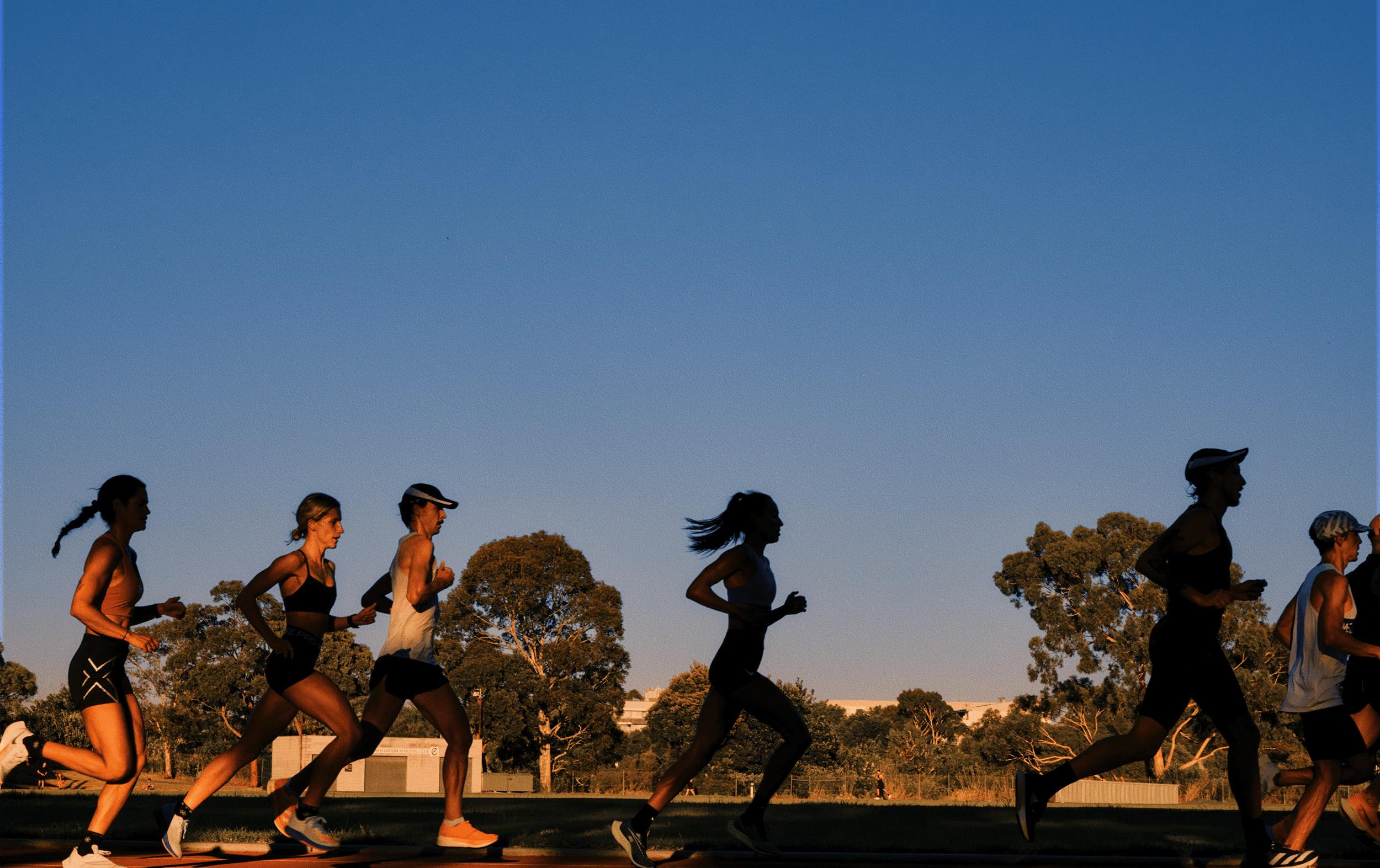 A group of people running around a track.
