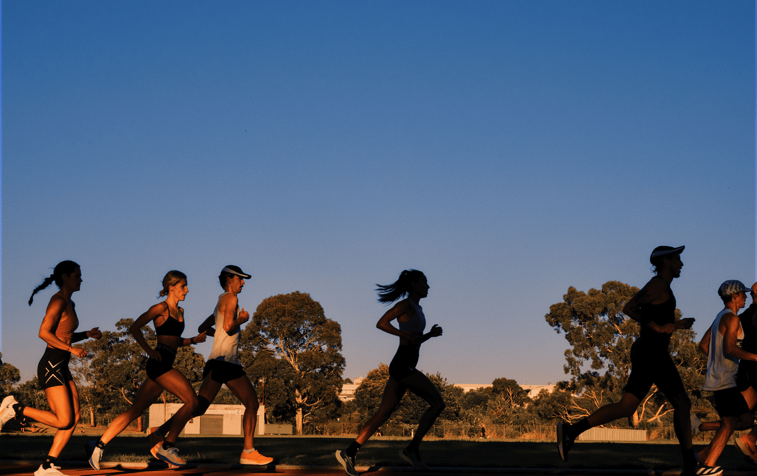 A group of people running around a track.