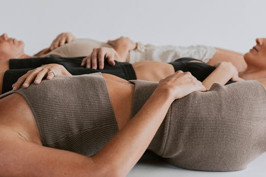 three women laying on the floor in a yoga studio