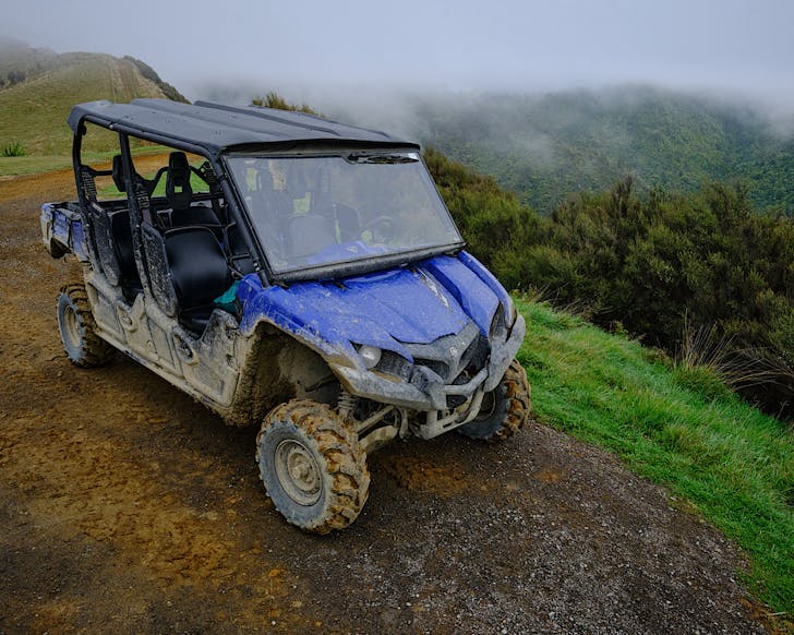 A muddy blue ATV